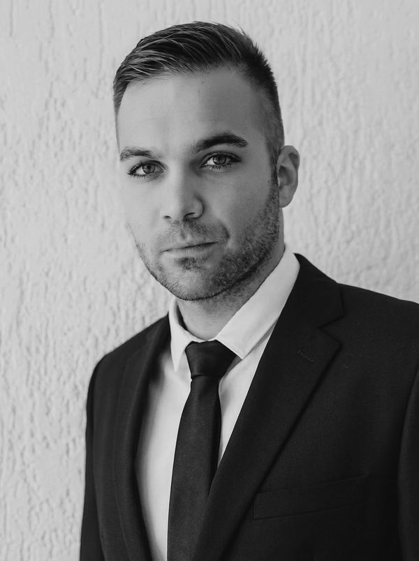 Duje Koceić, portret u tamnom odijelu pred svijetlim zidom
